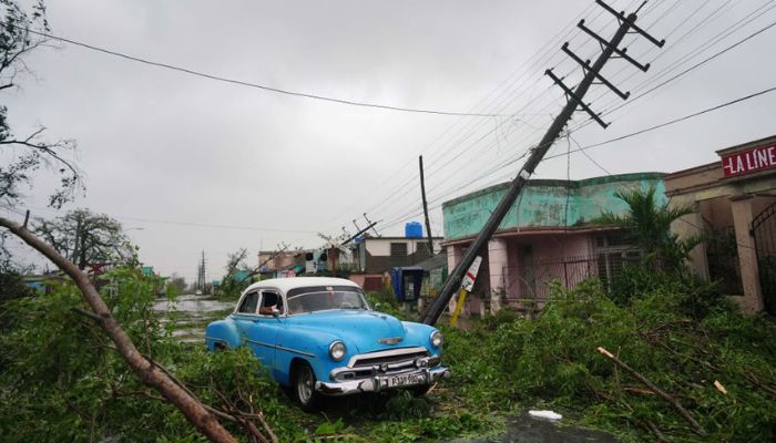 A vintage car passes by debris caused by the Hurricane Ian as it passed in Pinar del Rio, Cuba, September 27, 2022. — Reuters