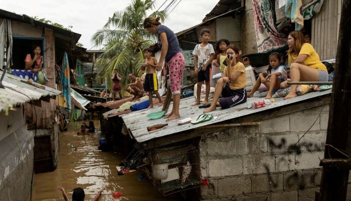 Residents wait on the roof of their homes for the flooding to subside after Super Typhoon Noru, in San Miguel, Bulacan province, Philippines, September 26, 2022. — Reuters
