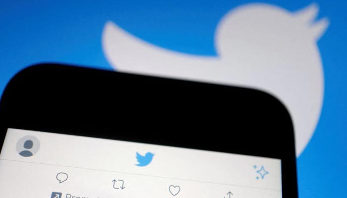 A promoted tweet on Twitter app is displayed on a mobile phone near a Twitter logo, in this illustration picture taken Sept. 8, 2022. — Reuters/File
