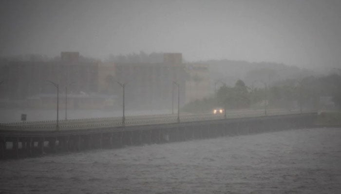 28 ستمبر 2022 کو امریکی ریاست فلوریڈا کے فورٹ مائرز میں سمندری طوفان ایان سے پہلے کالوسہاٹچی پل پر ایک کار نظر آ رہی ہے۔ — رائٹرز