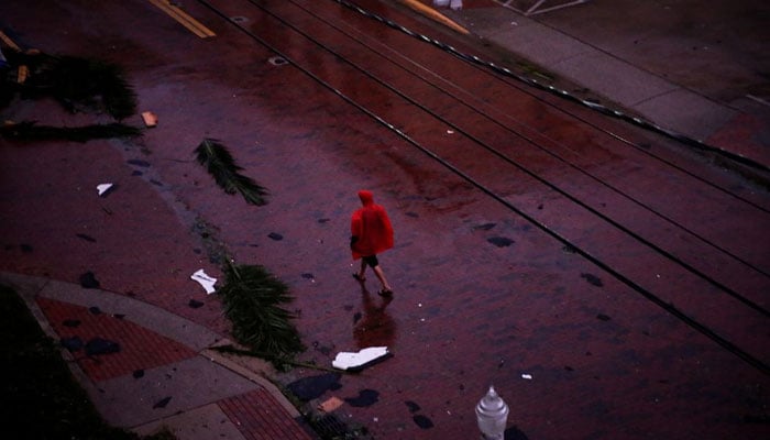 A man walks among fallen palm leaves and debris in a street in downtown as Hurricane Ian makes landfall in southwestern Florida, in Fort Myers, Florida, US September 28, 2022. — Reuters