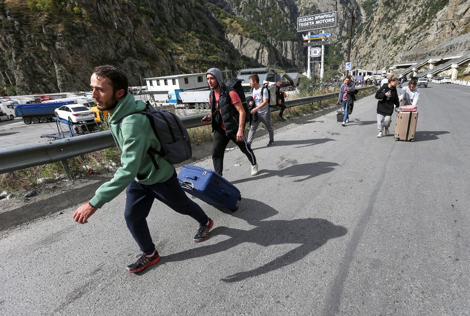 Travellers walk after crossing the border with Russia at the frontier checkpoint Verkhny Lars - Zemo Larsi, Georgia September 28, 2022.