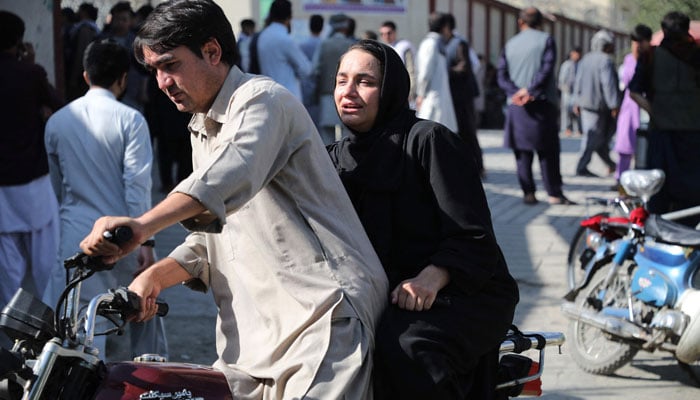 A woman arrives on a motorbike to search for a relative at a hospital in Kabul on September 30, 2022 after a blast in a learning centre in the Dasht-e-Barchi area of Afghanistans capital.  — AFP