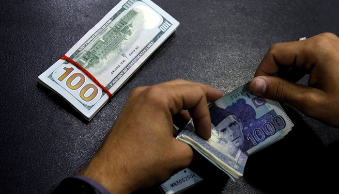 A currency trader counts Pakistani Rupee notes as he prepares an exchange of U.S dollars in Islamabad, Pakistan December 11, 2017. — Reuters