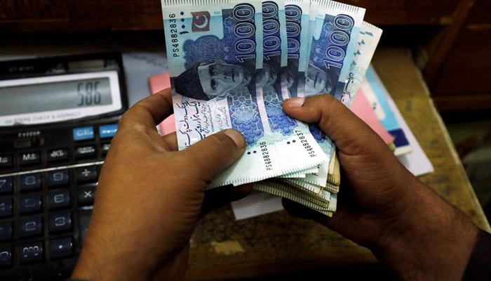 A trader counts Pakistani rupee notes at a currency exchange booth in Peshawar, Pakistan December 3, 2018. — Reuters/File