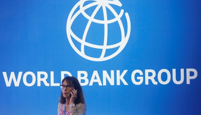 A participant stands near a logo of World Bank at the International Monetary Fund - World Bank Annual Meeting 2018 in Nusa Dua, Bali, Indonesia, October 12, 2018.— Reuters