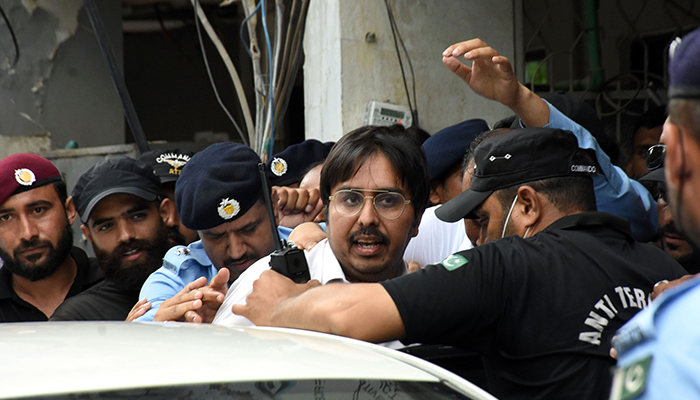 Police officers escort the leader of PTI Doctor Shahbaz Gill after a hearing at a district court in Islamabad, on August 24, 2022. — Online