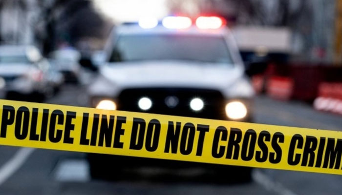Image showing a police tape against the background of a police vehicle. — AFP/ File