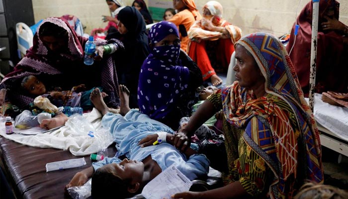سیلاب سے متاثرہ خواتین ملیریا اور بخار میں مبتلا اپنے بچوں کے ساتھ بیٹھی ہیں، جب وہ سہون، پاکستان کے سید عبداللہ شاہ انسٹی ٹیوٹ آف میڈیکل سائنسز میں 29 ستمبر 2022 کو طبی امداد حاصل کر رہی ہیں۔ — رائٹرز/فائل