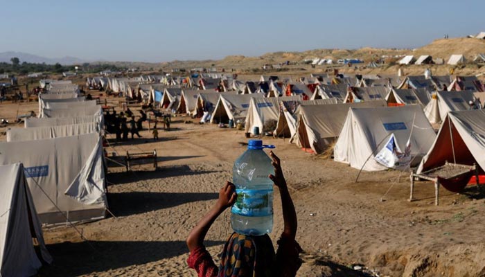 A displaced girl carries a bottle of water she filled from nearby stranded flood-waters, as her family takes refuge in a camp, in Sehwan, Pakistan, September 30, 2022. — Reuters/File