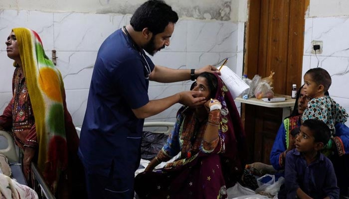 Naveed Ahmed, 30, a doctor, gives medical assistance to flood-affected girl Hameeda, 15, suffering from malaria at Sayed Abdullah Shah Institute of Medical Sciences in Sehwan, Pakistan September 29, 2022. — Reuters/File