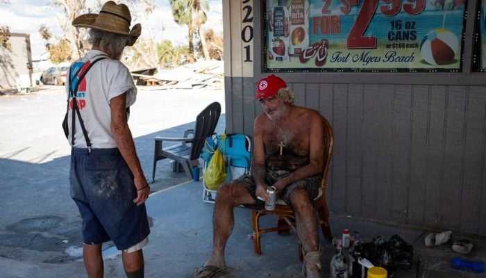 Men relax at a gas station after Hurricane Ian caused widespread destruction in Fort Myers Beach, Florida, U.S., October 3, 2022.— Reuters