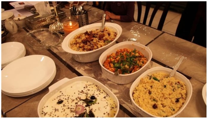 Image showing a variety of Pakistani dishes served on a table. — APP