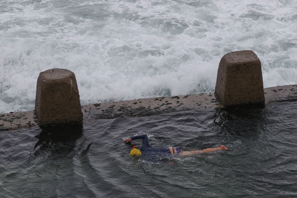 ایک شخص چٹان کے تالاب میں تیراکی کرتا ہے جبکہ بڑی لہریں Coogee بیچ پر پہنچ رہی ہیں، کیونکہ شدید بارش سڈنی، آسٹریلیا، 6 اکتوبر 2022 کو متاثر کرتی ہے۔