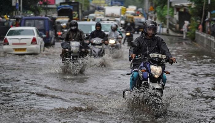 People drive through a flooded street during heavy rains in Mumbai, India, August 4, 2020. Reuters