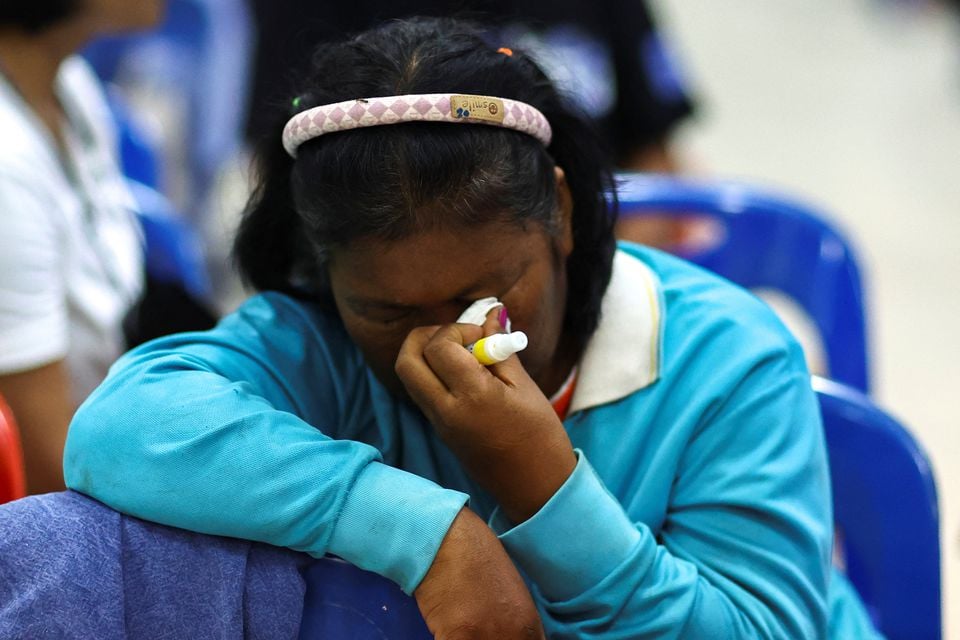 A woman reacts as people gather outside a day care center which was the scene of a mass shooting, in the town of Uthai Sawan, around 500 km northeast of Bangkok in the province of Nong Bua Lam Phu, Thailand October 6, 2022.