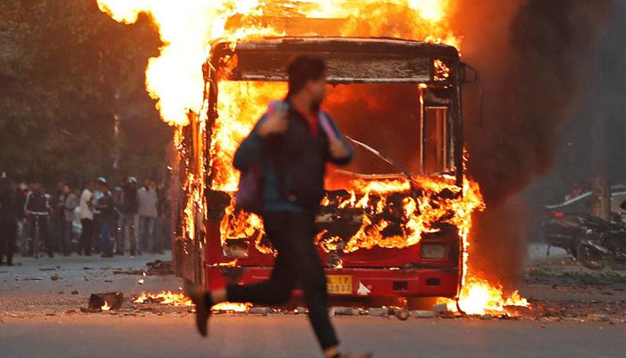 Representational image of man running past a burning bus on fire. — Reuters/File