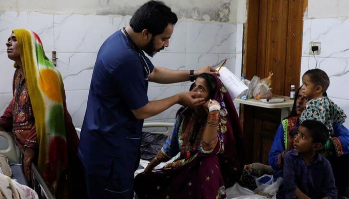 Naveed Ahmed, 30, a doctor, gives medical assistance to flood-affected girl Hameeda, 15, suffering from malaria at Sayed Abdullah Shah Institute of Medical Sciences in Sehwan, Pakistan September 29, 2022. — Reuters/File