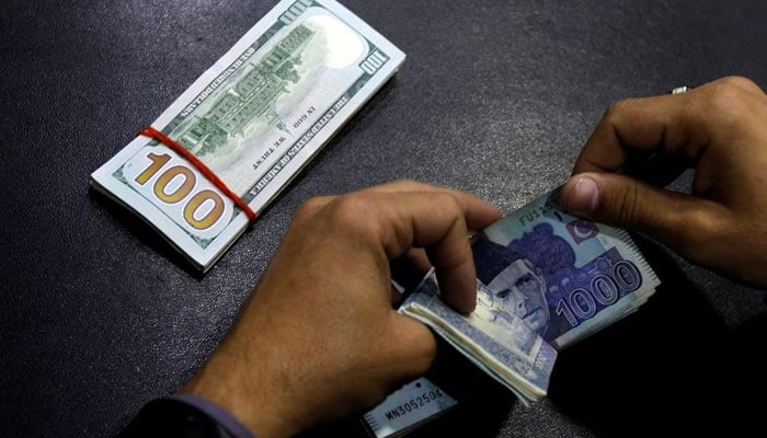 A currency trader counts Pakistani Rupee notes as he prepares an exchange of U.S dollars in Islamabad, Pakistan December 11, 2017. — Reuters/File