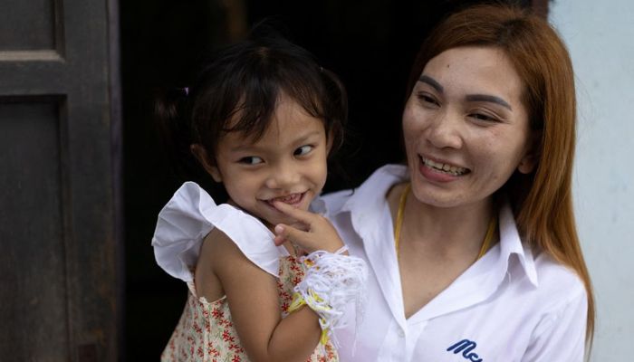 Panompai Sithong holds her 3-year-old daugther Paveenut Supolwong, nicknamed Ammy, who is the only child survivor of the day care centre mass shooting, during a family meeting at their home in Uthai Sawan, Nong Bua Lam Phu province, Thailand, October 9, 2022.— Reuters