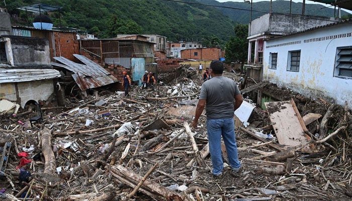 A resident looks at the rubble of destroyed houses washed away by a landslide during heavy rains in Las Tejerias, Aragua state, Venezuela, on October 9.—AFP