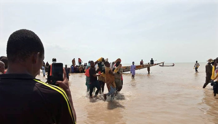 A man takes a picture as the body of one of the victims of a boat accident is being retrieved from the boat in Kebbi, Nigeria May 27, 2021. —REUTERS