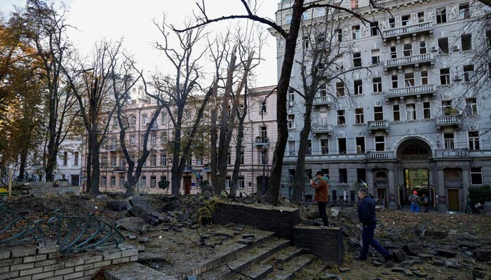 10 اکتوبر 2022 کو یوکرائن کے شہر کیف میں لوگ روسی میزائل حملوں کے منظر کا معائنہ کر رہے ہیں، جیسا کہ روس کا حملہ جاری ہے۔ - رائٹرز