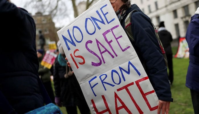 A protester holds a placard as she takes part in an anti-racism march in London, Britain on 16 March. — Reuters