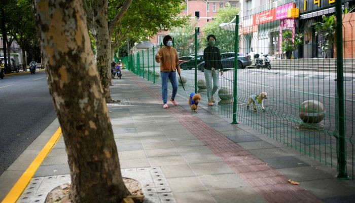 Women with dogs chat through gaps in a barrier at a sealed area, following the coronavirus disease (COVID-19) outbreak, in Shanghai, China October 11, 2022.— Reuters