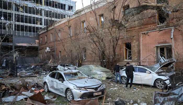 Local residents check their car, destroyed by the previous days Russian military strike, as Russias attack on Ukraine continues, in central Kyiv, Ukraine October 11, 2022. — Reuters