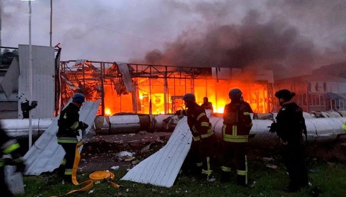 فائر فائٹرز کار خوردہ فروش کے دفتر کی عمارت کے مقام پر کام کر رہے ہیں، جو 11 اکتوبر 2022 کو یوکرائن کے شہر زپوریزہیا میں روسی میزائل حملے کے دوران تباہ ہو گئی تھی۔ — رائٹرز