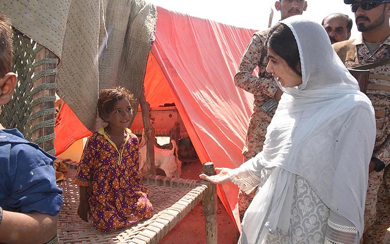 12 اکتوبر 2022 کو صوبہ سندھ کے وزیراعلیٰ ہاؤس آفس کی طرف سے لی گئی اور جاری کی گئی اس ہینڈ آؤٹ تصویر میں امن کی نوبل انعام یافتہ ملالہ یوسفزئی (ر) کو صوبہ سندھ کے ضلع دادو کے جوہی میں ایک عارضی کیمپ میں سیلاب سے متاثرہ خاندانوں سے ملاقات کرتے ہوئے دکھایا گیا ہے۔  - اے ایف پی