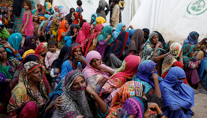 Women displaced because of the floods wait to receive food handouts while taking refuge in a camp, in Sehwan, Pakistan, September 30, 2022. — Reuters