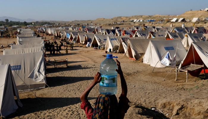 A displaced girl carries a bottle of water she filled from nearby stranded flood-waters, as her family takes refuge in a camp, in Sehwan, Pakistan, September 30, 2022. —REUTERS