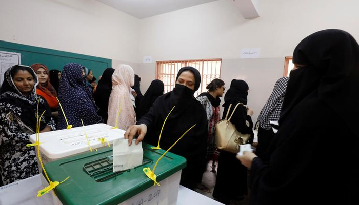 A woman casts her ballot while others wait for their turn at a polling station during the general election in Karachi, Pakistan, July 25, 2018. — Reuters