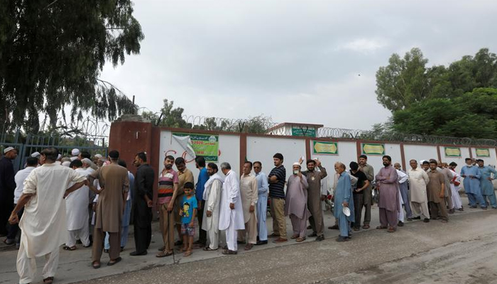 People stand in a line as they wait for a polling station to open, during general election in Rawalpindi, Pakistan July 25, 2018. — Reuters