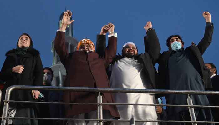 PDM leaders holding hands in a rally in Lahore. -AFP/File