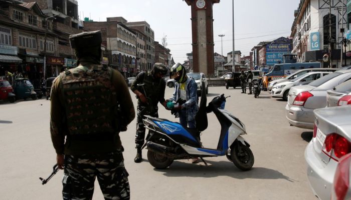 Indian Central Reserve Police Force (CRPF) personnel check the bags of a scooterist as part of security checking in Srinagar, October 12, 2021.— Reuters