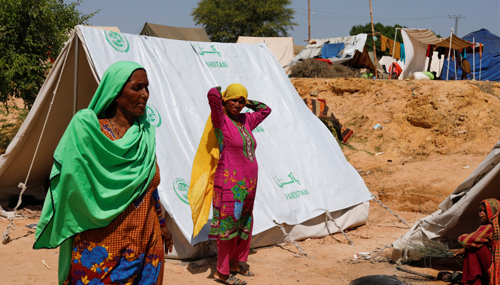 Displaced women stand outside their tent in a camp, following rains and floods during the monsoon season in Sehwan, Pakistan, September 16, 2022. —REUTERS