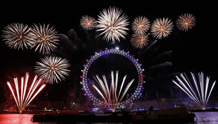 Fireworks take place in celebration of New Year in the backdrop of the London Eye in central London. — AFP/File