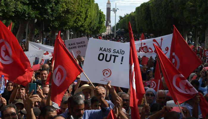 Supporters of the Tunisian Free Destourian Party wave national flags and raise placards during a demonstration against President Kais Saied in the capital Tunis, on October 15, 2022.— AFP