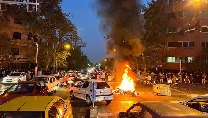 19 ستمبر 2022 کو تہران، ایران میں اسلامی جمہوریہ اخلاقی پولیس کے ہاتھوں گرفتار ہونے کے بعد ہلاک ہونے والی خاتون مہسا امینی کی موت پر احتجاج کے دوران پولیس کی ایک موٹر سائیکل جل رہی ہے۔ — رائٹرز/فائل