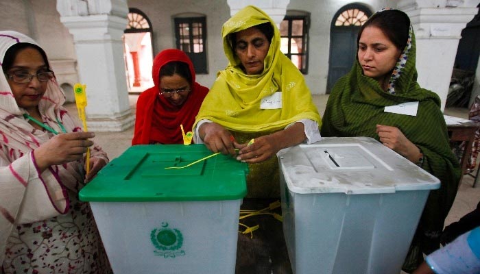 Staff of a polling station open ballot boxes to count votes. — Reuters/File