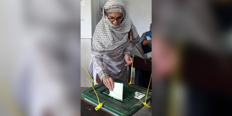 16 اکتوبر 2022 کو کراچی میں ایک پولنگ بوتھ پر ایک خاتون اپنا ووٹ ڈال رہی ہے۔ — آن لائن