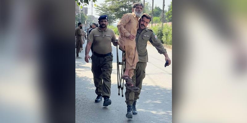 Police official in Faisalabad carries a special voter during by-election in NA-108, on October 16, 2022. — APP