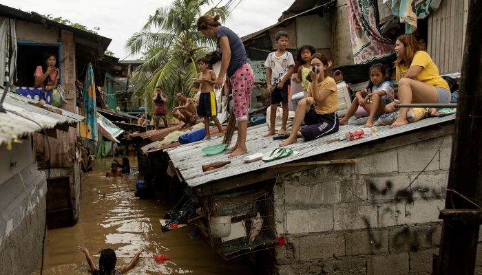 Residents wait on the roof of their homes for the flooding to subside after Super Typhoon Noru, in San Miguel, Bulacan province, Philippines, September 26, 2022.— Reuters