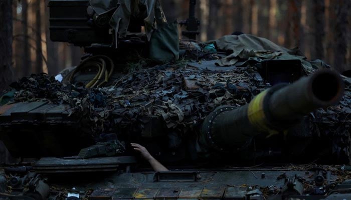15 اکتوبر 2022 کو یوکرین کے خارکیو اوبلاست کے کوپیانسک علاقے میں، ایک یوکرائنی فوجی مرمت کرتے وقت ٹینک سے اپنا ہاتھ نکال رہا ہے۔ — رائٹرز/فائل