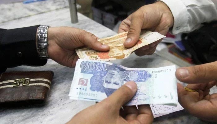 Pakistani rupee declines in value against US dollar for fifth consecutive session - Financeupdates 1 Men exchange Pakistani banknotes at a shop counter in Peshawar, Pakistan, on November 17, 2017. — Reuters