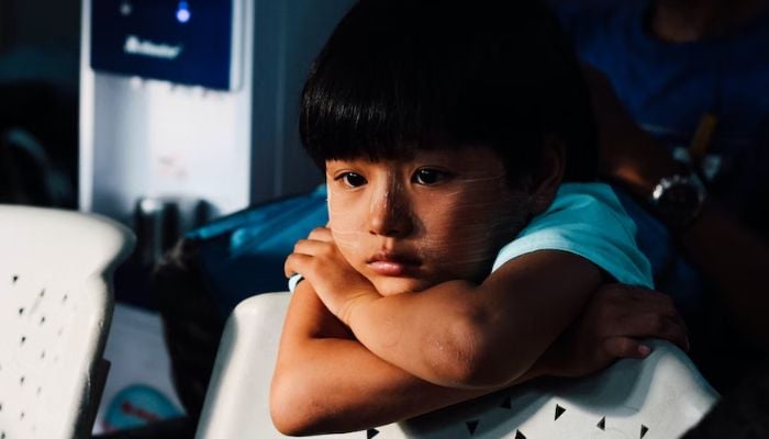 Child with his hands on a chair.— Unsplash