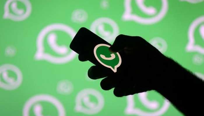 A man poses with a smartphone in front of displayed Whatsapp logo in this illustration September 14, 2017. — Reuters/File